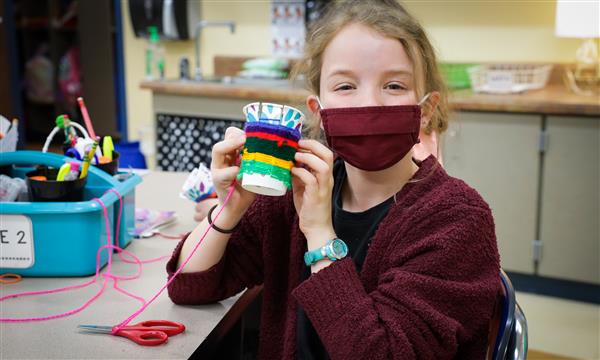 student creates woven craft